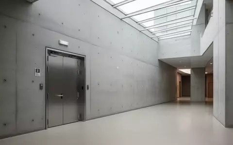 Ein minimalistischer Flur in einem öffentlichen Gebäude mit einer massiven Brandschutztür in einer Betonwand. - Foto: über boerse-global.de