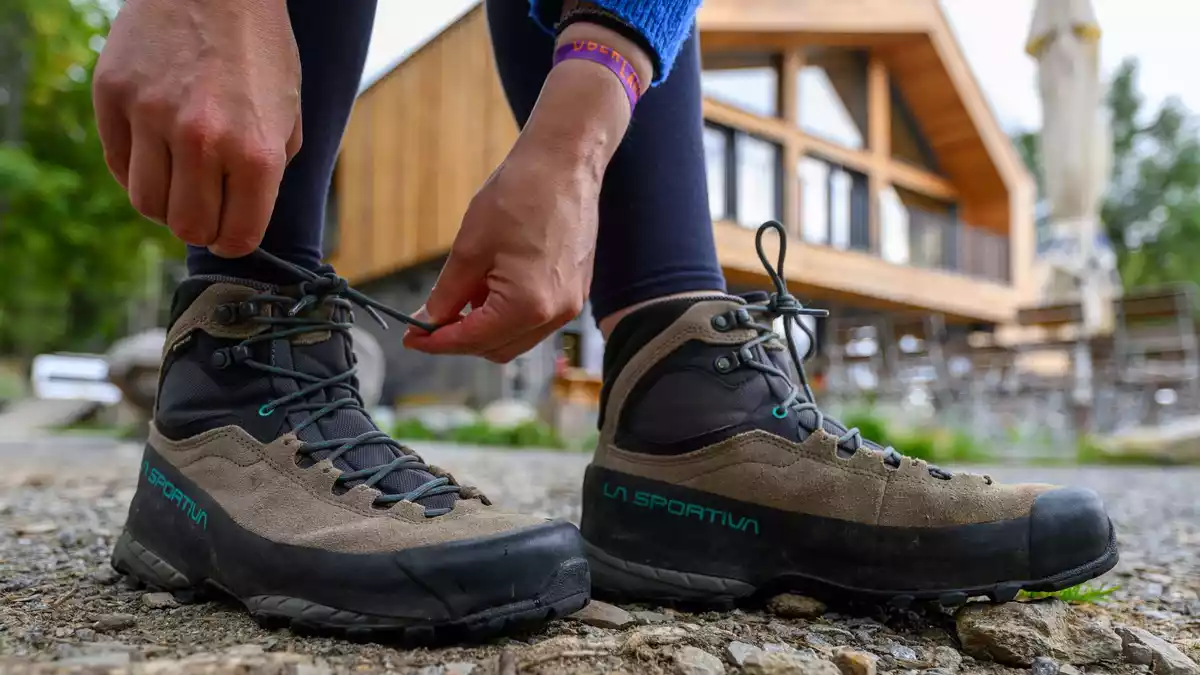 Eine Frau schnürt ihre Wanderschuhe. Deutschland gilt mit seinen vielfältigen Landschaften und Regionen als Wanderland.  - Bild: Hendrik Schmidt/dpa