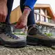 Eine Frau schnürt ihre Wanderschuhe. Deutschland gilt mit seinen vielfältigen Landschaften und Regionen als Wanderland.  - Bild: Hendrik Schmidt/dpa