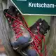 Wanderschuhe stehen in einem Wegweiser am Fuß des Fichtelbergs. - Bild: Hendrik Schmidt/dpa