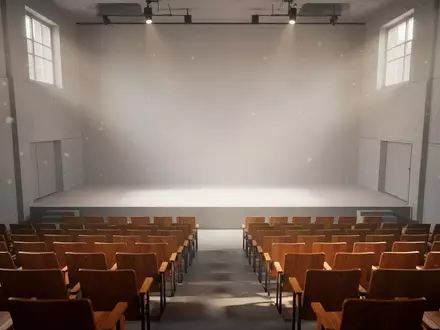 Ein minimalistischer, leerer Hörsaal mit Reihen aus Holzstühlen und hellem, natürlichem Tageslicht, das auf die Bühne fällt. - Foto: über boerse-global.de