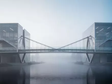 Eine moderne, minimalistische Brücke aus Glas und Stahl, die zwei architektonische Strukturen in einer nebligen Umgebung verbindet. - Foto: über boerse-global.de