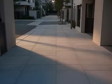 Eine leere, moderne städtische Straße in der Dämmerung mit langen Schatten und architektonischen Strukturen. - Foto: über boerse-global.de