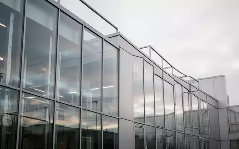 Moderne Glasfassade eines Laborgebäudes bei bewölktem Himmel als Symbol für die strategische Neuausrichtung. - Foto: über boerse-global.de