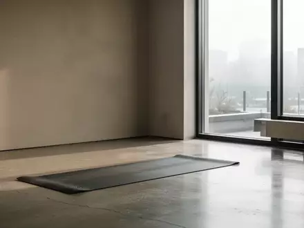 Eine leere, ruhige Ecke in einem Fitnessstudio mit einer einzelnen Yogamatte auf dem Boden, beleuchtet durch natürliches Licht. - Foto: über boerse-global.de