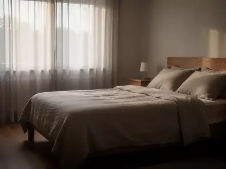 Ein ruhig gestaltetes, minimalistisches Schlafzimmer mit sanftem Morgenlicht und einem unbenutzten, ordentlich gemachten Bett. - Foto: über boerse-global.de