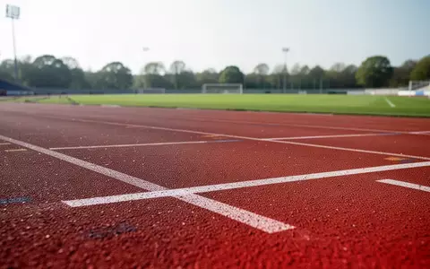 Eine leere, rote Kunststofflaufbahn in einem Stadion bei Tageslicht. - Foto: über boerse-global.de