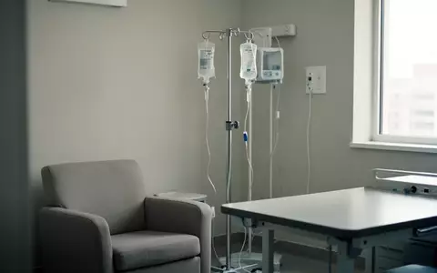 Ein steriler, hell beleuchteter Behandlungsraum in einer Klinik mit einem Infusionsständer und einem bequemen Sessel. - Foto: über boerse-global.de