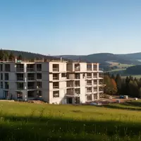 Rohbau moderner Mehrfamilienhäuser in einer hügeligen Waldlandschaft im Erzgebirge bei Tageslicht. - Foto: über boerse-global.de