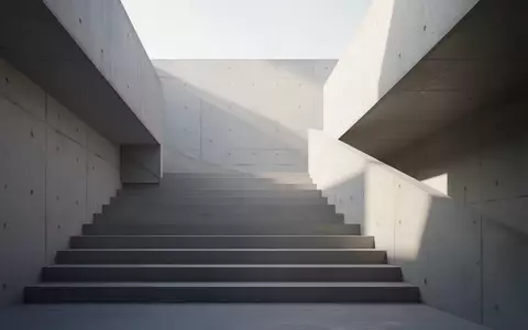 Eine moderne, minimalistische Betontreppe in einem hellen, architektonischen Raum mit klaren geometrischen Schatten. - Foto: über boerse-global.de