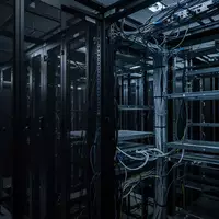 Dunkler Serverraum mit leeren Serverschränken und komplexer Verkabelung in einer kontrollierten Umgebung. - Foto: über boerse-global.de