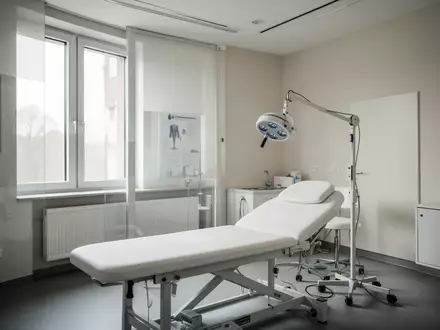 Ein leerer, modern eingerichteter Behandlungsraum in einer Arztpraxis mit einer Untersuchungsliege und hellem Tageslicht. - Foto: über boerse-global.de
