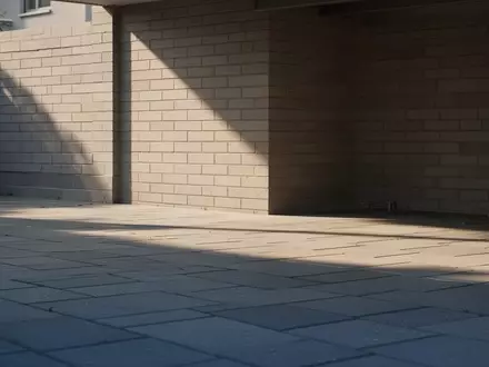 Ein sonnenbeschienener, leerer Fahrradabstellplatz vor einer neutralen Backsteinwand - Foto: über boerse-global.de