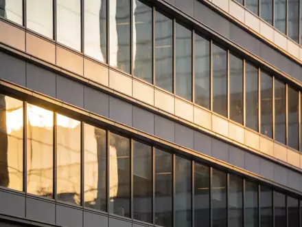 Moderne Glasfassade eines Bürogebäudes im Finanzviertel bei Sonnenuntergang. - Foto: über boerse-global.de