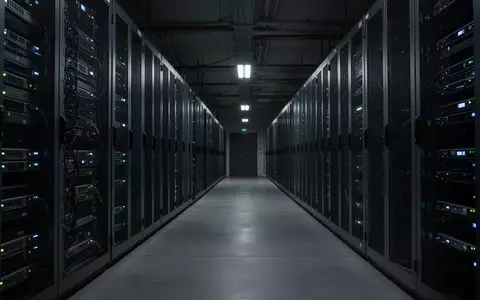 Ein dunkler, moderner Serverraum mit leuchtenden LED-Anzeigen an metallischen Serverschränken. - Foto: über boerse-global.de