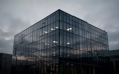Ein modernes, minimalistisches Bürogebäude in der Dämmerung, das die zunehmende Unsicherheit in der Führungsebene symbolisiert. - Foto: über boerse-global.de