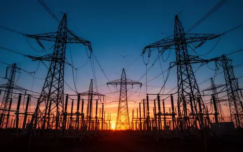 Ein großes Umspannwerk mit Hochspannungsmasten in der Dämmerung, das den massiven Energiebedarf der digitalen Industrie versinnbildlicht. - Foto: über boerse-global.de