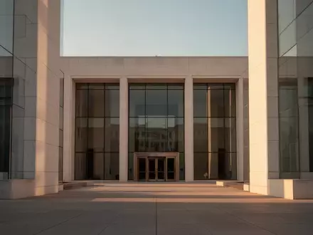 Eine moderne, minimalistische Steinfassade eines Regierungsgebäudes bei Sonnenuntergang. - Foto: über boerse-global.de