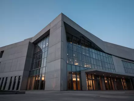 Moderne Fassade eines Behördengebäudes aus Beton und Glas bei Dämmerung - Foto: über boerse-global.de