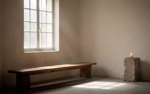 Ein ruhiger, minimalistischer Raum mit einer schlichten Holzbank und natürlichem Licht, das durch ein Fenster fällt. - Foto: über boerse-global.de