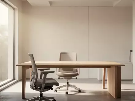 Ein minimalistischer, heller Arbeitsplatz mit einem leeren Schreibtisch und ergonomischem Stuhl in einem ruhigen Raum. - Foto: über boerse-global.de
