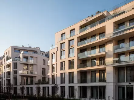 Modernes Wohnquartier mit hellen Fassaden und Balkonen in einer städtischen Umgebung bei Tageslicht. - Foto: über boerse-global.de
