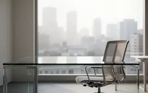 Ein minimalistisches, helles Büro mit einem leeren Schreibtisch und einem ergonomischen Stuhl in natürlichem Morgenlicht. - Foto: über boerse-global.de
