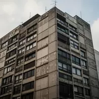 Ein in die Jahre gekommenes Hochhaus aus den 1970er Jahren vor einem bewölkten Himmel. - Foto: über boerse-global.de