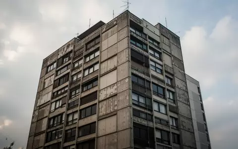 Ein in die Jahre gekommenes Hochhaus aus den 1970er Jahren vor einem bewölkten Himmel. - Foto: über boerse-global.de