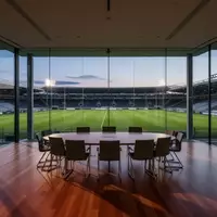 Ein leerer, moderner Sitzungssaal mit Blick auf ein Fußballstadion in der Abenddämmerung. - Foto: über boerse-global.de