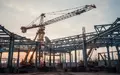 Ein Industriekran auf einer Baustelle unter einem bewölkten Morgenhimmel als Symbol für wirtschaftliche Entwicklung. - Foto: über boerse-global.de