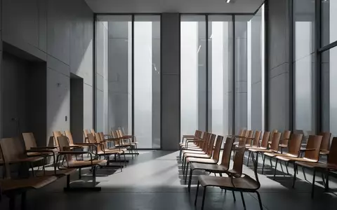 Leerer, minimalistischer Warteraum in einem Sozialgericht mit schlichten Holzstühlen und hellem Tageslicht. - Foto: über boerse-global.de
