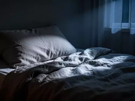 Ein ungemachtes Bett in einem dunklen, nächtlichen Schlafzimmer, beleuchtet durch sanftes Mondlicht. - Foto: über boerse-global.de