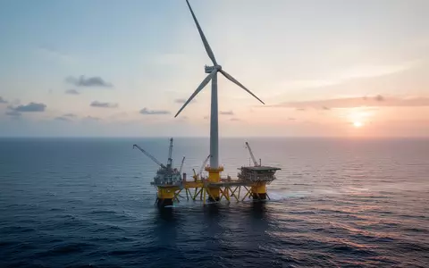 Ein groĂes schwimmendes Offshore-Windrad auf dem offenen Meer bei Sonnenaufgang. - Foto: ĂŒber boerse-global.de