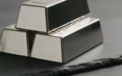 Mehrere glänzende Silberbarren, die auf einer dunklen Schieferoberfläche gestapelt sind. - Foto: über boerse-global.de