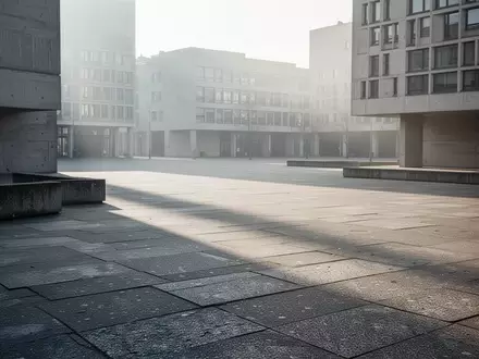 Ein leerer, sonnendurchfluteter Betonplatz vor moderner Architektur in einer städtischen Umgebung. - Foto: über boerse-global.de