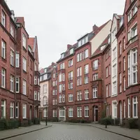 Eine ruhige Wohnstraße mit Backsteingebäuden in einem deutschen Stadtviertel bei Tageslicht. - Foto: über boerse-global.de