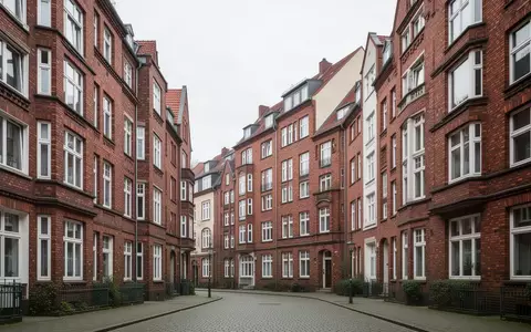 Eine ruhige Wohnstraße mit Backsteingebäuden in einem deutschen Stadtviertel bei Tageslicht. - Foto: über boerse-global.de