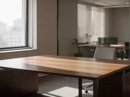 Ein minimalistischer, leerer Schreibtisch in einem hellen, modernen Bürogebäude bei Tageslicht. - Foto: über boerse-global.de