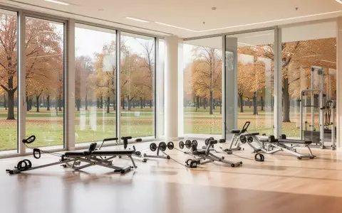 Ein heller, minimalistischer Trainingsraum mit großen Fenstern und Blick in einen Park, ausgestattet mit professionellen Geräten. - Foto: über boerse-global.de