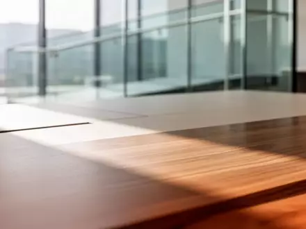 Minimalistischer, heller Arbeitsbereich mit fokussiertem Lichtspiel auf einer Holzoberfläche ohne technische Geräte. - Foto: über boerse-global.de