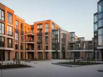 Moderne Wohnanlage mit klarer Architektur bei Sonnenlicht. - Foto: über boerse-global.de