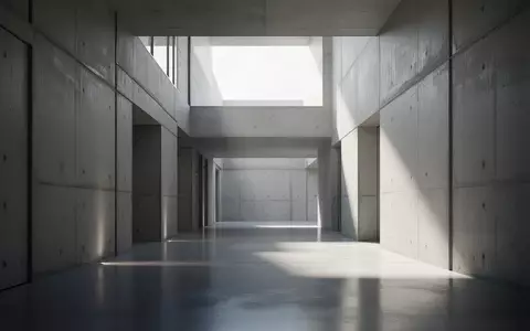 Ein minimalistischer, moderner Flur mit Betonwänden und diffusem Tageslicht, der eine ruhige und strukturierte Umgebung darstellt. - Foto: über boerse-global.de