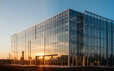 Moderne Glasfassade eines Bürogebäudes bei Sonnenuntergang. - Foto: über boerse-global.de
