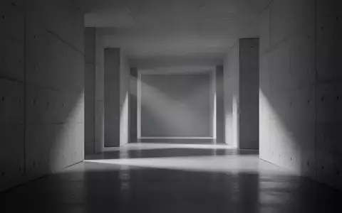 Ein minimalistischer, modern gestalteter Flur mit schlichten Betonwänden und diffusem Licht, der eine Atmosphäre technischer Komplexität erzeugt. - Foto: über boerse-global.de