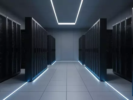 Ein moderner, minimalistischer Serverraum mit symmetrischen Reihen dunkler Metallschränke in einer kühlen, bläulichen Atmosphäre. - Foto: über boerse-global.de