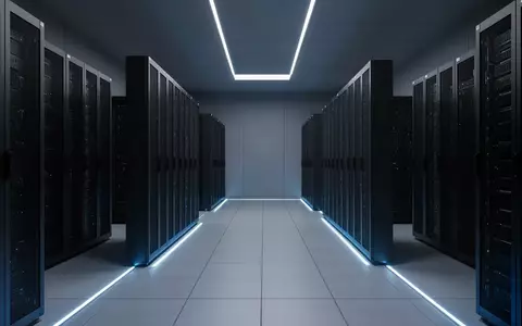 Ein moderner, minimalistischer Serverraum mit symmetrischen Reihen dunkler Metallschränke in einer kühlen, bläulichen Atmosphäre. - Foto: über boerse-global.de