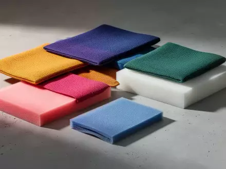 Eine Nahaufnahme von hochwertigen Textil- und Polstermaterialien in verschiedenen Farben auf einer neutralen Oberfläche. - Foto: über boerse-global.de