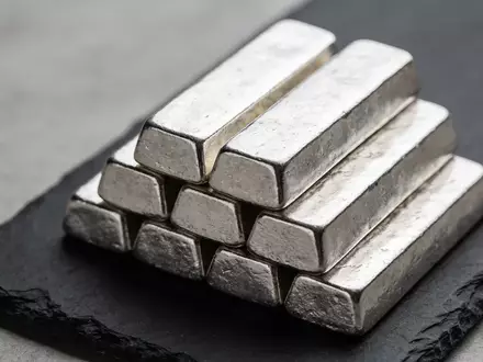 Stapel aus silbernen Barren auf einer dunklen Schieferplatte bei natürlichem Licht. - Foto: über boerse-global.de