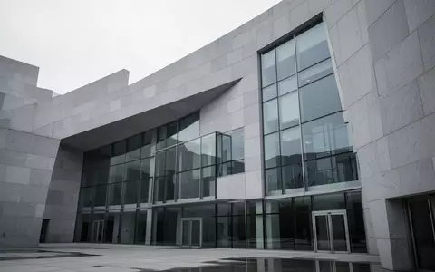 Moderne, minimalistische Fassade eines Behördengebäudes aus Stein und Glas bei Tageslicht. - Foto: über boerse-global.de